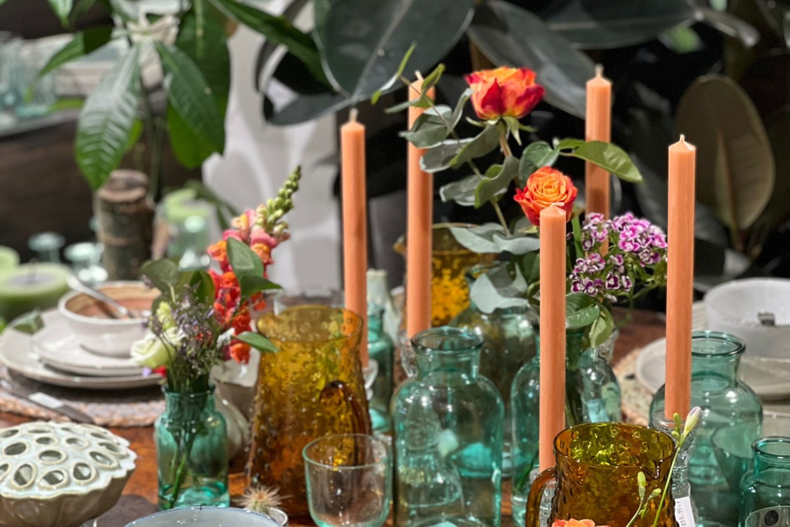 Table with tableware and orange stick candles.