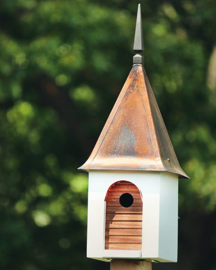Light blue Bird Nesting Station with pointy metal roof on a wooden beam